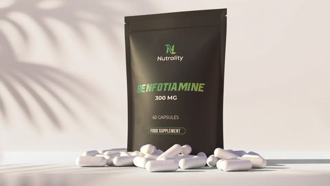 A black stand-up pouch labeled 'Nutrality Benfotiamine 300 MG' stands on a light surface with white capsules scattered in front. The pouch is photographed in a clean studio setting with soft shadow overlays.